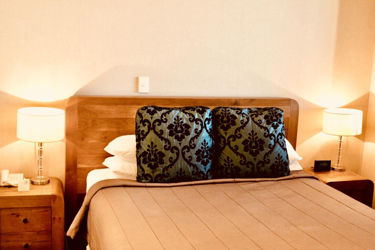 The Nautilus Hotel Napier Bagian luar foto A bed with a decorative pillow