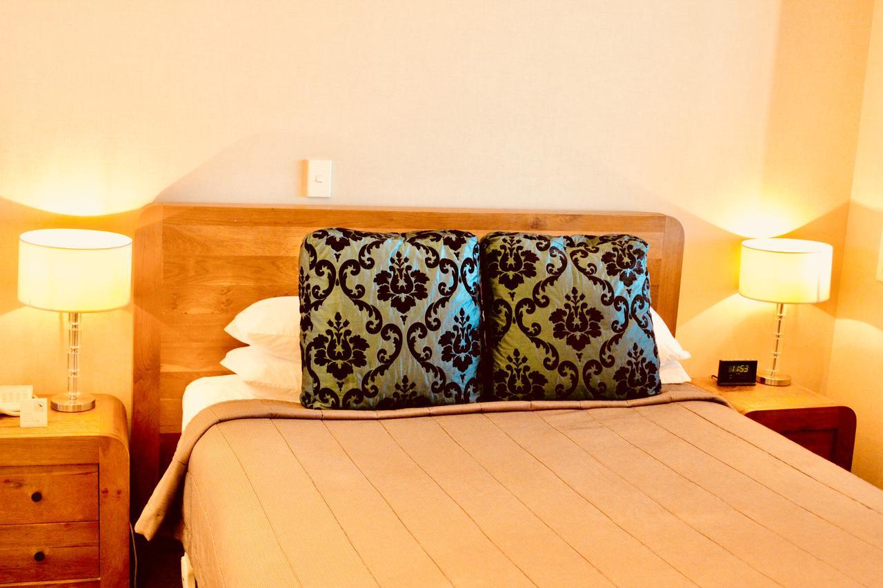 The Nautilus Hotel Napier Bagian luar foto A bed with a decorative pillow